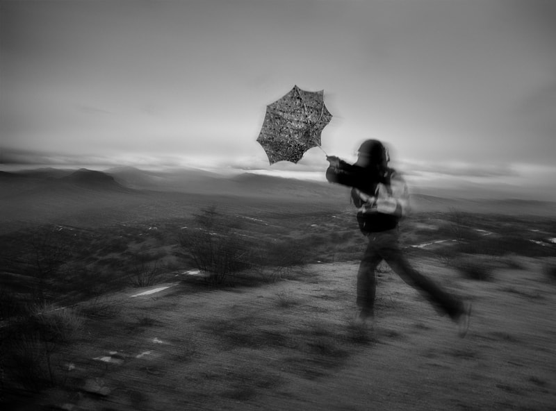 Black and White image of Umbrella being blown inside out during a storm